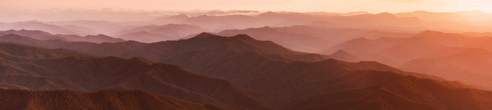 A landscape image of sunset over mountains used for our Lemon Myrtle Essential Oil